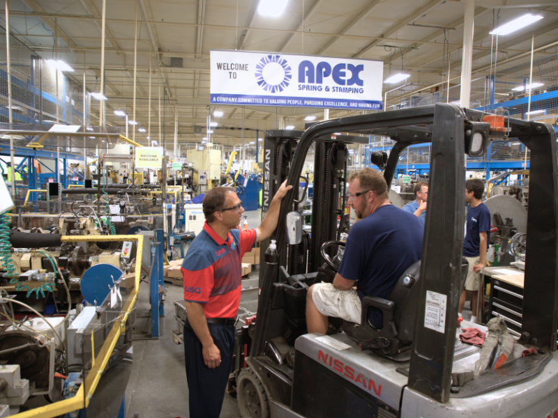 CEO talking to team member on production floor.