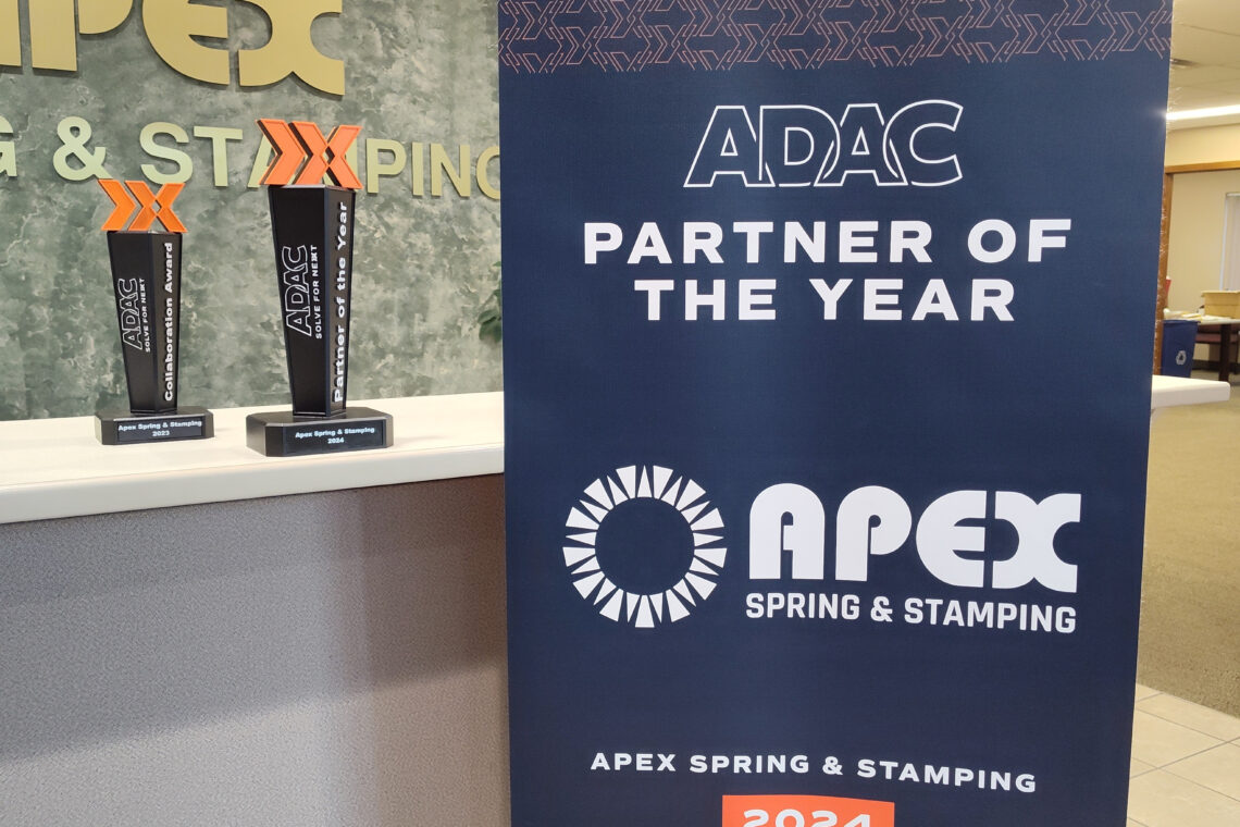 Photo of the ADAC Banner and two awards presented in 2023 and 2024 to Apex Spring and Stamping