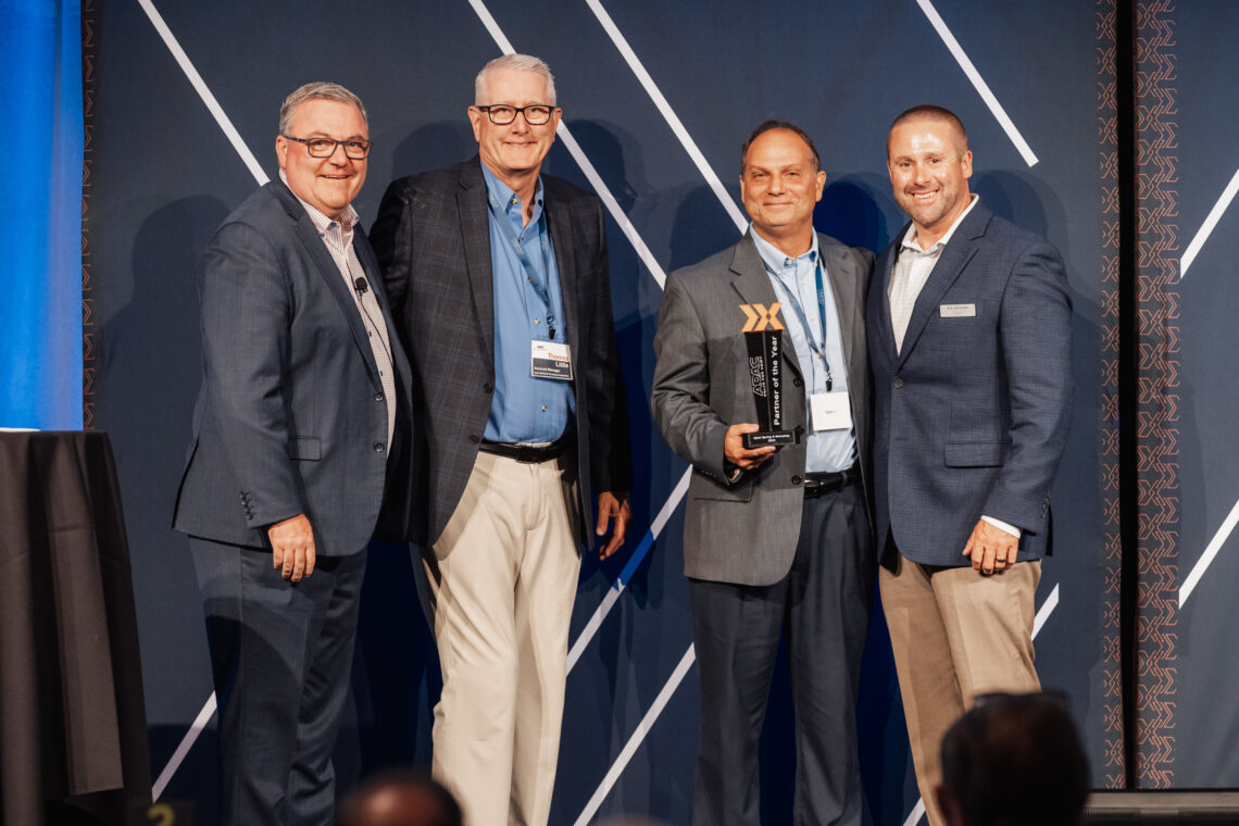 Image of two Apex employees being presented with a trophy and awarded the 2025 ADAC partner of the year.